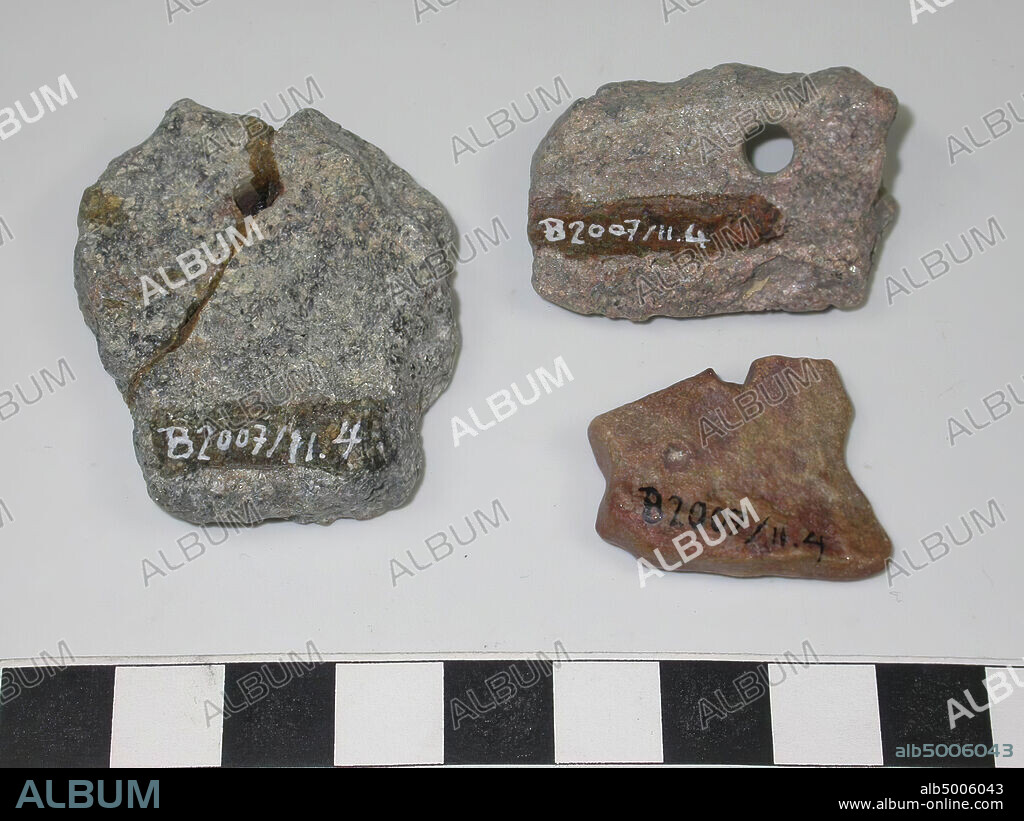 4 pieces of pierced stone, 2 of which glued together. 2 pieces are gray-black, 1 piece gray-red and 1 reddish. All pieces of stone have broken edges and are pierced., Varia, ornament, stone, largest: L 4.4 cm, W 3.5 cm., Smallest: L 2.7 cm, W 2.3 cm., Saudi Arabia.
