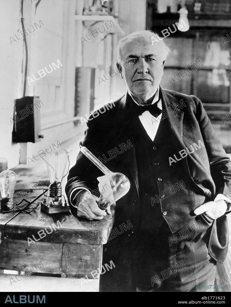 Thomas Alva Edison in his laboratory. American inventor Thomas Alva Edison holding a light bulb in his laboratory. Menlo Park, 1910s.