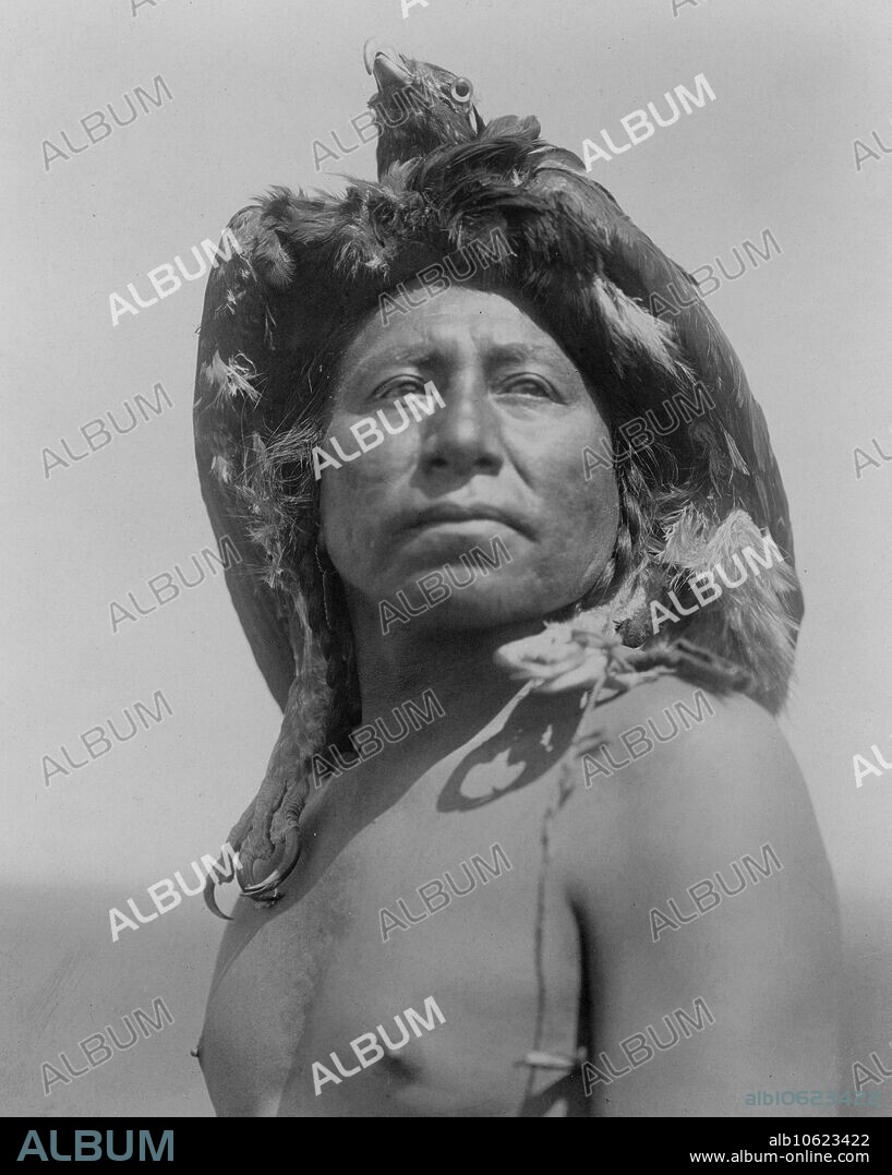 EDWARD SHERIFF CURTIS. The Eagle Medicine-Man-Apsaroke, c1908. Photo shows an Apsaroke shaman, head-and-shoulders portrait, facing front, wearing eagle headdress.