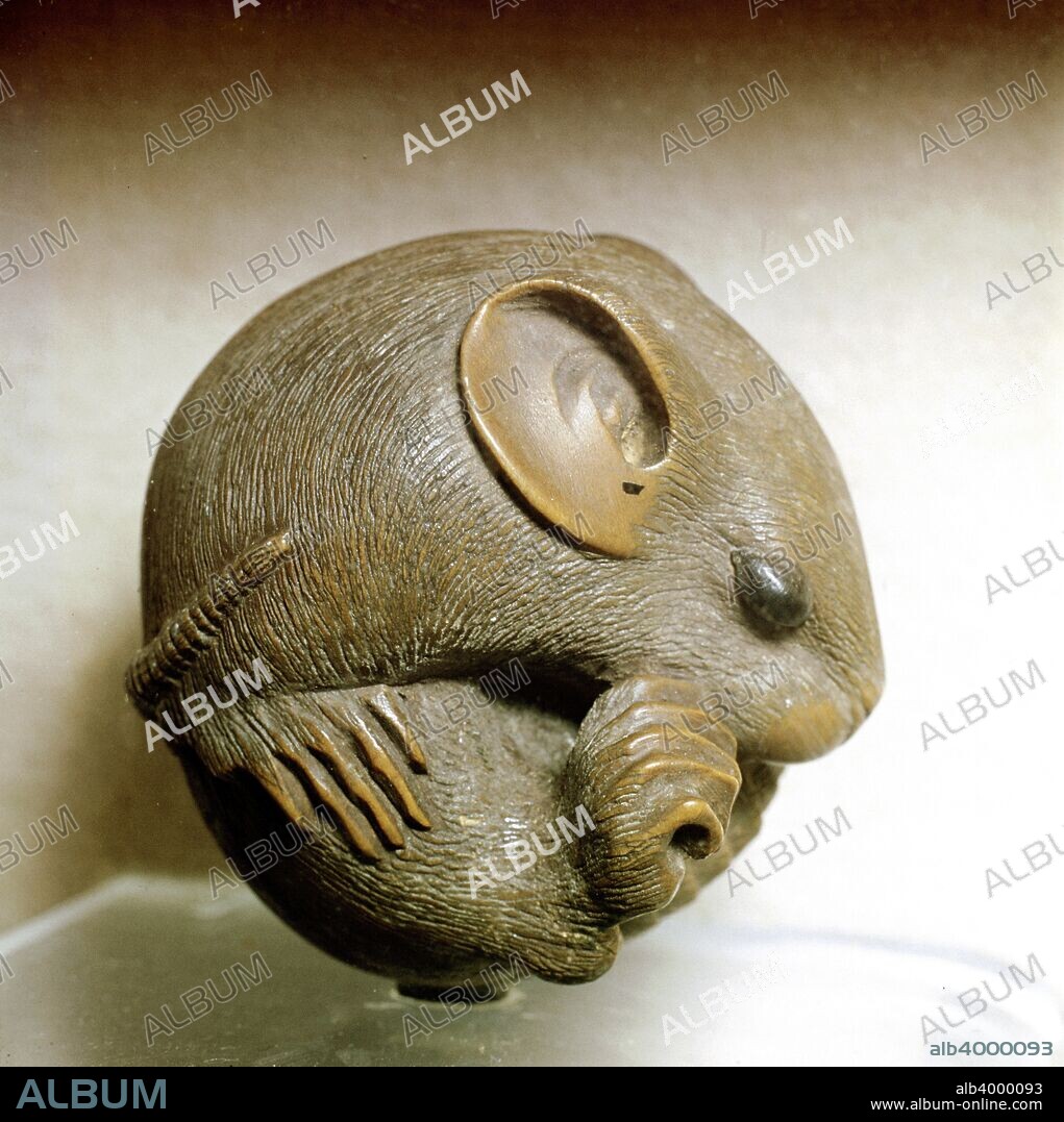 Netsuke carved in the form of a rat, one of the 12 animals of the Japanese zodiac. A netsuke is a fastening for attaching a pouch for carrying personal items (inro) to the sash of a kimono. The inro and netsuke evolved as a solution to the problem of the traditional kimono having no pockets in which to carry items. Initially functional in design, they evolved into intricately carved decorative forms. Materials used included bone, ivory, and various types of wood. Although kimonos have been superseded by western dress in modern Japan, the art of netsuke carving lives on. From the Victoria and Albert Museum, London.