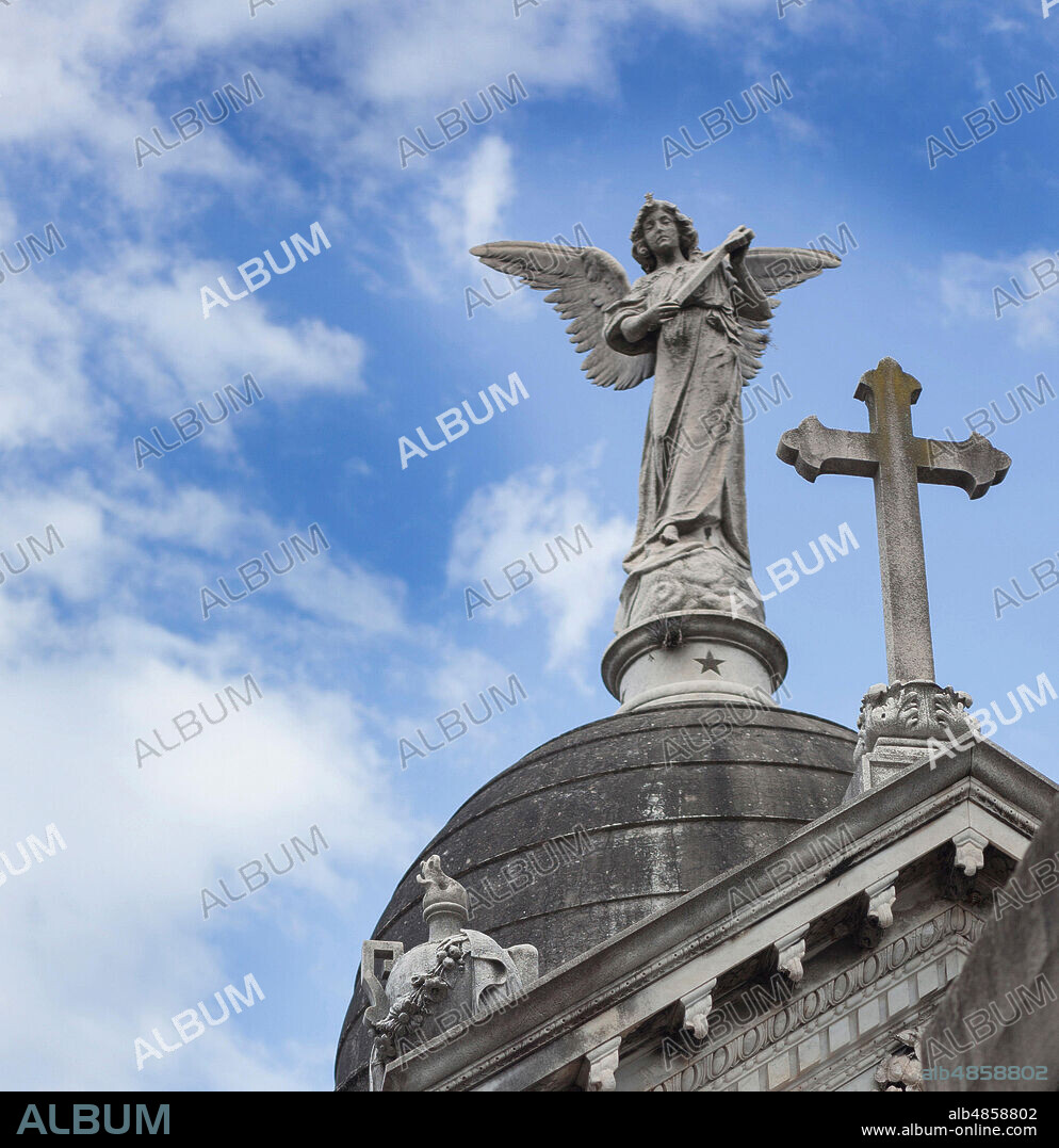 Escultura de ángel portando una cruz, sobre la cúpula de Mausoleo.