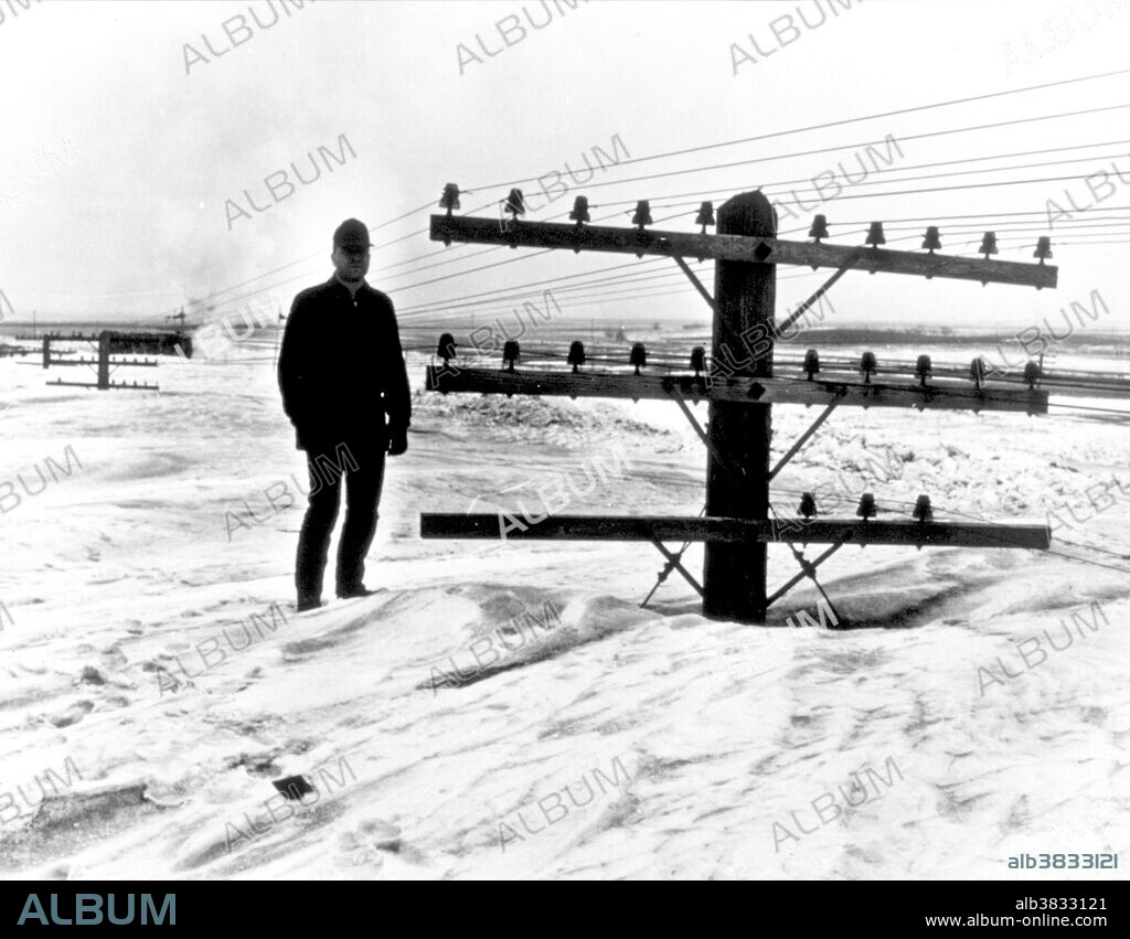 Standing tall on North Dakota snow. A March blizzard nearly buried utility poles. Caption jokingly read "I believe there is a train under here somewhere!" Jamestown, North Dakota March 9, 1966.
