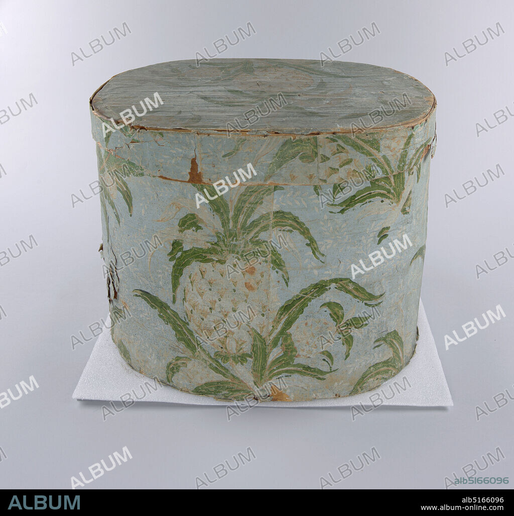 Pineapple, Hannah Davis, 1784 1863, Block-printed paper on wood support; lined with newsprint, Wooden bandbox covered in wallpaper with pineapple pattern. Coloring of exposed areas much faded, better preserved paper sample with vivid coloring around rim. Turquoise-green background (light blue in exposed areas) with background fill of deep pink dots (white in exposed areas), white trailing leaves and flowers, bold repeating pattern of cluster of three pineapples in white and pinks with green leaves. Lined with newsprint: 'Christian Panoply'. Paper label inside lid: 'Warranted/ Nailed/ Bandboxes/ Made by/ Hannah Davis'., Jaffrey, New Hampshire, USA, 1840, Wallcoverings, Bandbox, Bandbox.