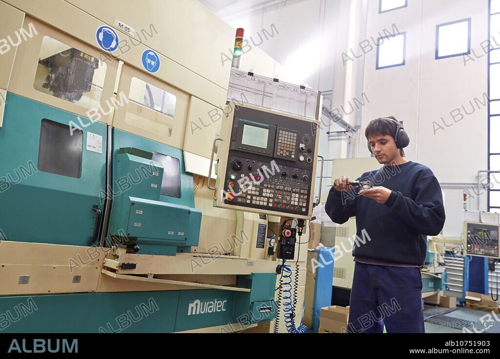 Worker measuring with caliper. Area automated CNC lathes. Machined Indecober. Machining of precision parts in series. Automotive industry. Berriz. Bizkaia. Basque Country. Spain.