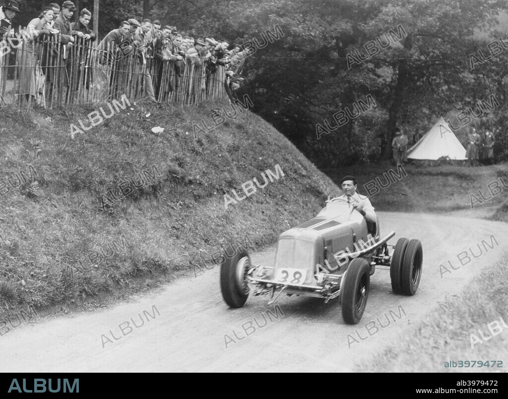 Raymond Mays in an ERA car, c1934-c1939. Mays was a racing driver of the pre-war period, and played an important role in the creation of the ERA (English Racing Automobiles Ltd) cars. He started racing in 1921 with a Hillman, specialising in hillclimbs and sprint events. He also raced Bugattis, ACs and Vauxhalls. With Victor Riley he built the 'White Riley' and with the sponsorship from Humphrey Cook the project developed into the ERA. Mays was co-founder and head driver of the team and the cars were built on his home yard at Bourne. In 1937 ERA and Mays dominated the Voiturette season. In 1939 Mays raced his ERA as an independent. He retired from racing after the 1949 International Trophy.