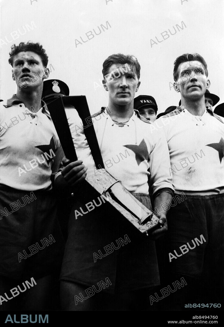 ARKIV NORRKÖPING 1943-11-14. IFK Norrköpings Birger Bian Rosengren (mitten) håller i Svenska Cup-pokalen omgiven av lagkamraterna Kalle Johansson (t. v.) och Gösta Malm (t. h.) efter att ha besgrat AIK med 5-2 i den andra och avgörande cup-finalen i Norrköping 14:e november 1943.. Foto: BM-Bild / TT / Kod: 194.