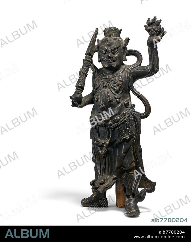 ATTENDANT OF BRAHMA WITH PHURBU AND FLAMING WHEEL.<br><br>China. Ming/Qing dynasty. 17th/18th c. Bronze with dark patina. Rare depiction. Probl. part of a larger setting on an altar. Height 28.5cm. On the back: Royal Brahma, no 2 from the left. Condition A/B. Casting defect at the feet and back. Art trade, Van Ham.