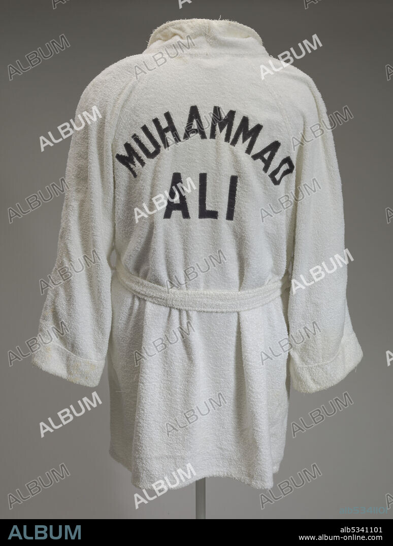 INC. EVERLAST WORLDWIDE. White terry cloth Everlast robe worn by Muhammad Ali at the 5th Street Gym, a boxing gym in Miami Beach, Florida. Ali became World Heavyweight Boxing Champion the same year. Robe includes a terry cloth belt. On the front right panel, situated on the upper chest, is a label for the brand in worn black letters. [EVERLAST/MADE IN U. S. A./Made Expressly for MUHAMMED ALI]. On the back sewn in large black letters is Muhammad Ali's name [MUHAMMED/ALI].
