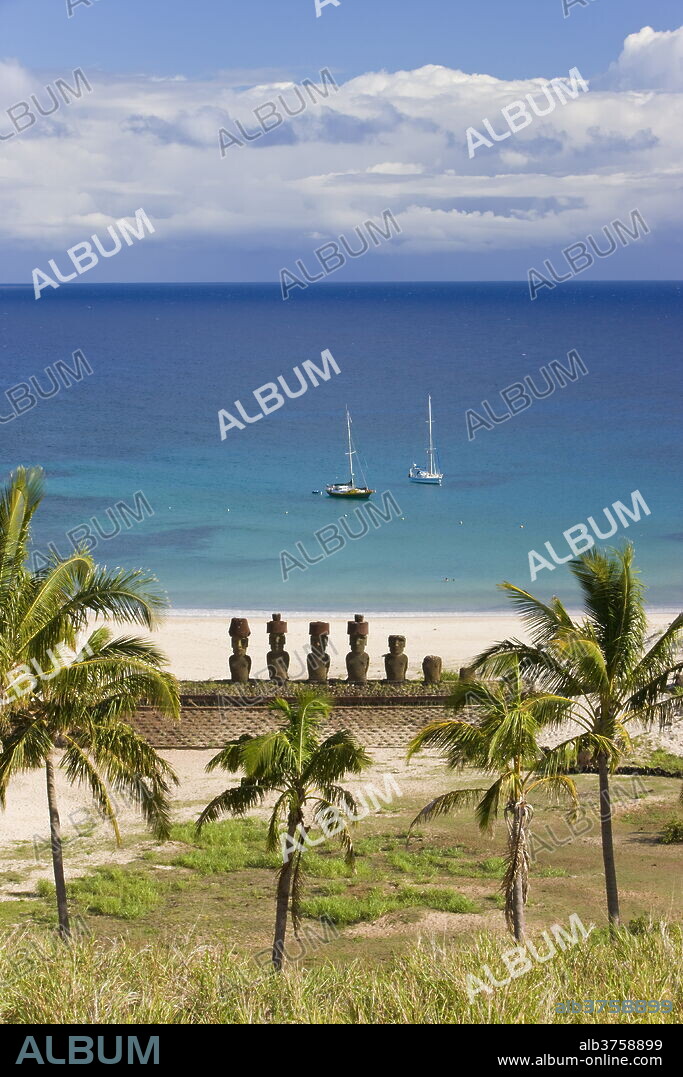 Anakena beach, yachts moored in front of the monolithic giant stone Moai statues of Ahu Nau Nau, four of which have topknots, Rapa Nui (Easter Island), UNESCO World Heritage Site, Chile, South America.