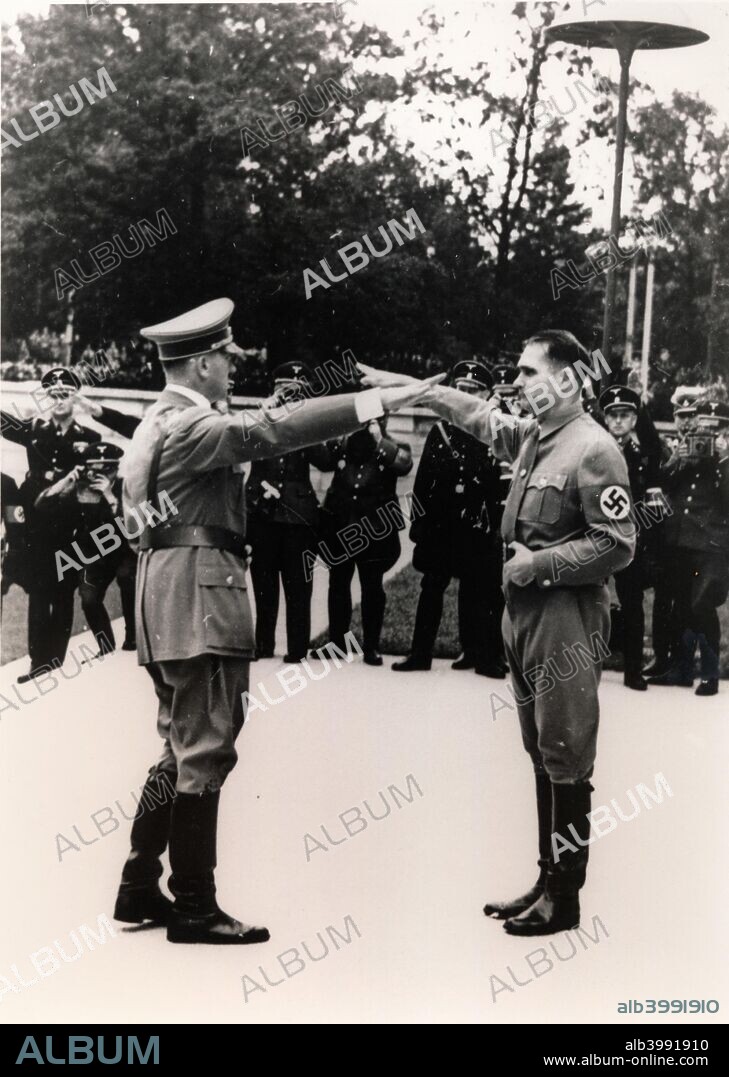 Nazi leaders Adolf Hitler and Rudolf Hess exchanging salutes, c1930s-c1940s. Hitler (1889-1945) appointed Hess (1894-1987) his deputy as leader of the Nazi Party in 1933, soon after the Nazis came to power. This effectively made Hess the third most powerful figure in Nazi Germany, after Hitler and Hermann Goering. In 1941, just before the German invasion of the Soviet Union, he flew to Scotland, ostensibly to begin peace negotiations with the British government. His plane crash landed near Eaglesham, Renfrewshire and he was arrested and spent the rest of the war as a POW. Found guilty of war crimes at the Nuremberg Trials in 1946, Hess spent the rest of his life in Spandau Prison in Berlin.