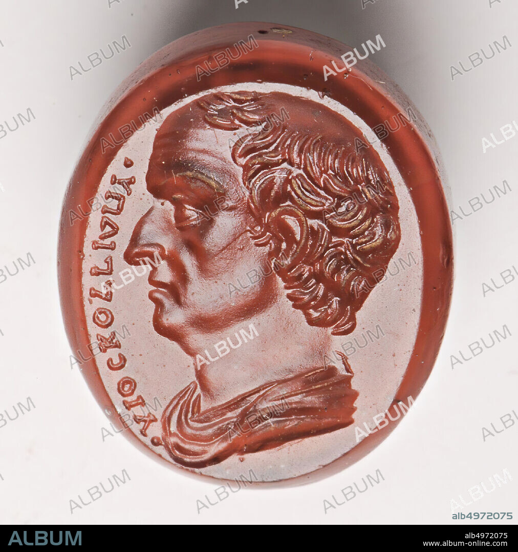 Vz: the man has a bald head, wrinkled forehead and a robe around his shoulders, gem, intaglio, unknown, Color: red-orange, Shape: oval, Processing: edge at the front slightly receding with respect to the middle from the edge, 12 x 15 x 4 mm,?.