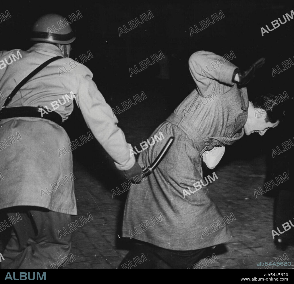 Rome General Strike: Police Use Truncheons - A man (right) is struck down by a policeman's rubber truncheon as police broke up a demonstration during the second day of Rome's General strike, Dec. 12. the strike ended at midnight, Dec. 12, when an agreement was reached on the chamber of Labour's demand for a £5,500,000 programme of unemployment relief works. December 14, 1947. (Photo by Associated Press Photo).