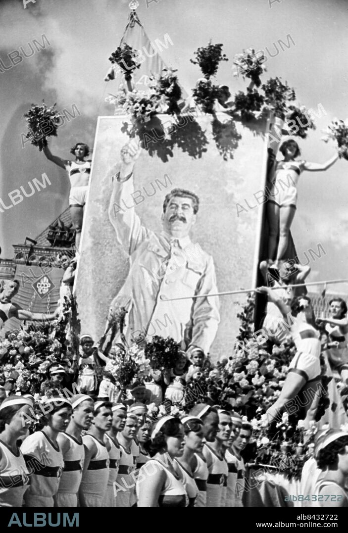 SOVJETUNIONEN MOSKVA 1935-06-30.. En sportparad äger rum på Röda torget i Moskva. Här ses några idrottsmän från föreningen Dynamo smycka ett stort porträtt av Josef Stalin med blommor.. Foto: Sojusfoto / AB Text & Bilder / SVT / Kod: 5600. Tysk originalbildtext.. Mapp: Sportparader 1935-1939 Sovjetunionen 5530E2d. Parader.