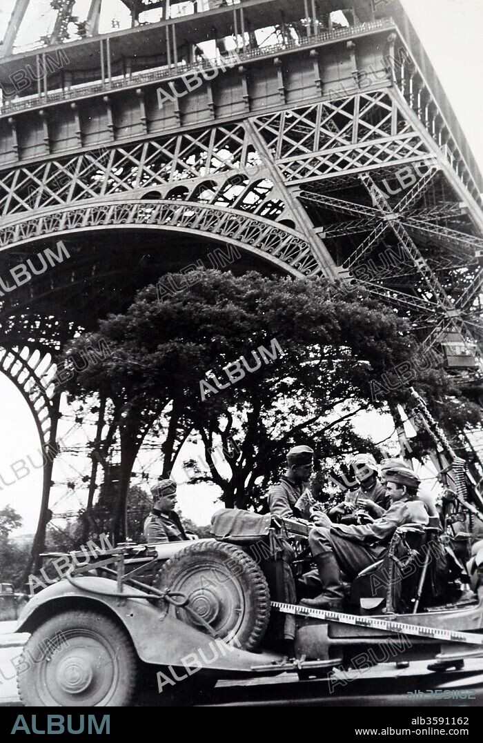 World War Two: German soldiers sit in a vehicle under the Eiffel Tower as they occupy Paris, during the invasion of France 1940. Dated 20th Century.