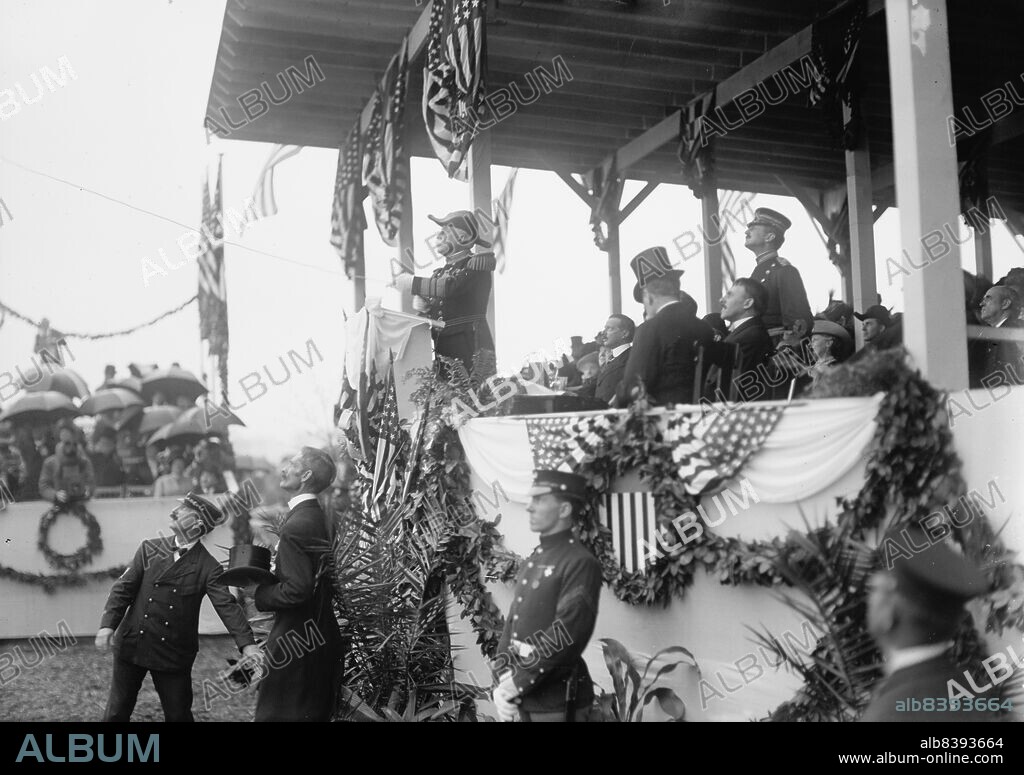HARRIS & EWING. John Paul Jones Statue unveiling, Admiral George Dewey, U.S.N., 1912. [US Navy officer George Dewey pulls a rope to unveil the John Paul Jones Memorial in Washington D.C. The sculpture, by Charles Henry Niehaus, commemorates the United States' first naval war hero, father of the US Navy, and the only naval officer to receive a Congressional Gold Medal during the American Revolutionary War].