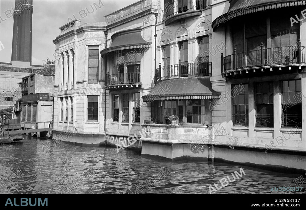 The Trafalgar Hotel, Greenwich, London, c1945-c1965. The Trafalgar Hotel (formerly Tavern) in Park Row, Greenwich, with its cast iron balconies and bow windows, is built right on the River Thames, remeniscent of Venetian architecture. Above the three central windows are shell-shaped designs; the blinds on the right are pulled down. The hotel was designed by Joseph Kay in 1837.