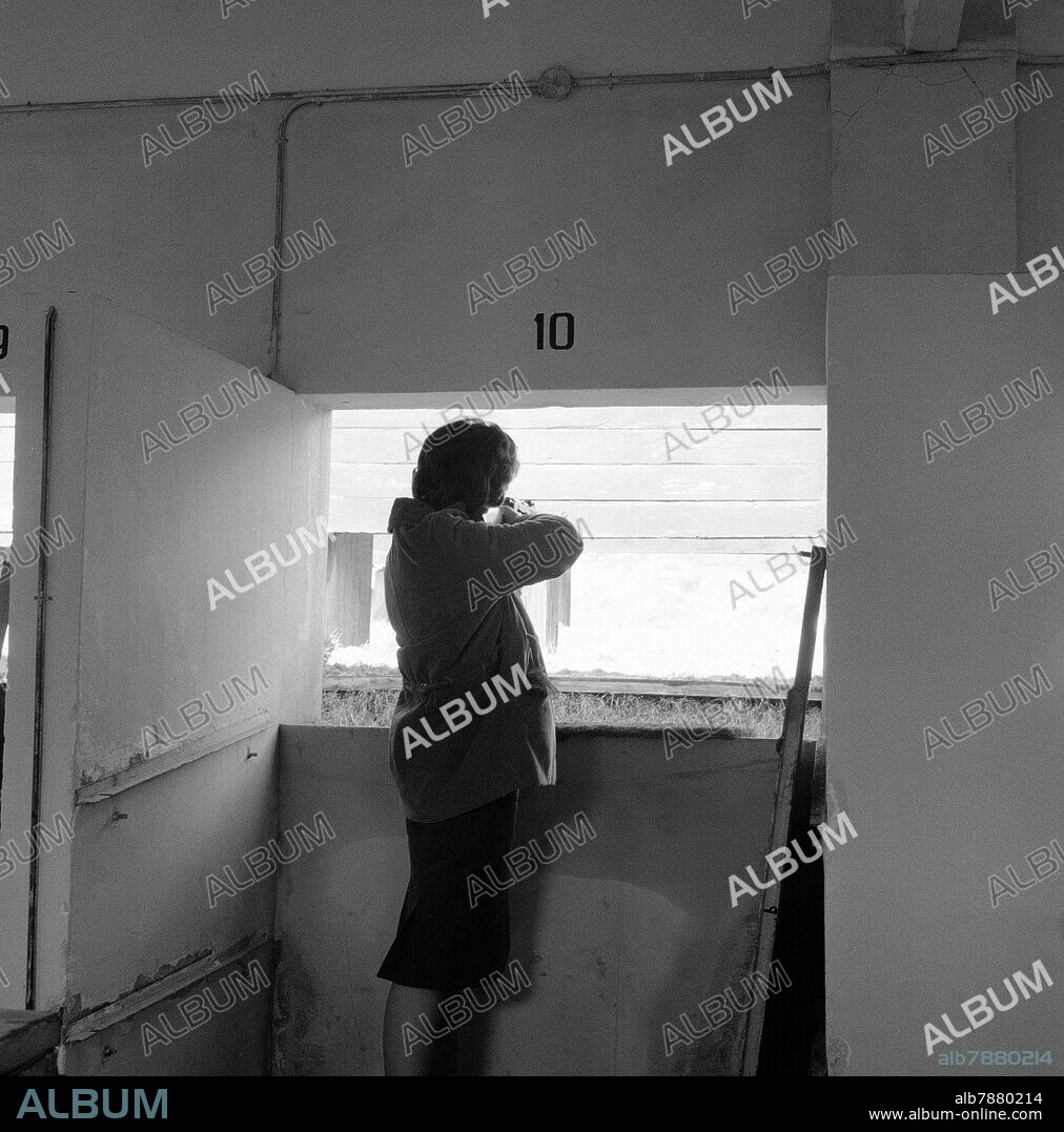 MUJER DISPARANDO EN EL CLUB DE TIRO - FOTOGRAFIA EN BLANCO Y NEGRO - AÑOS 60.