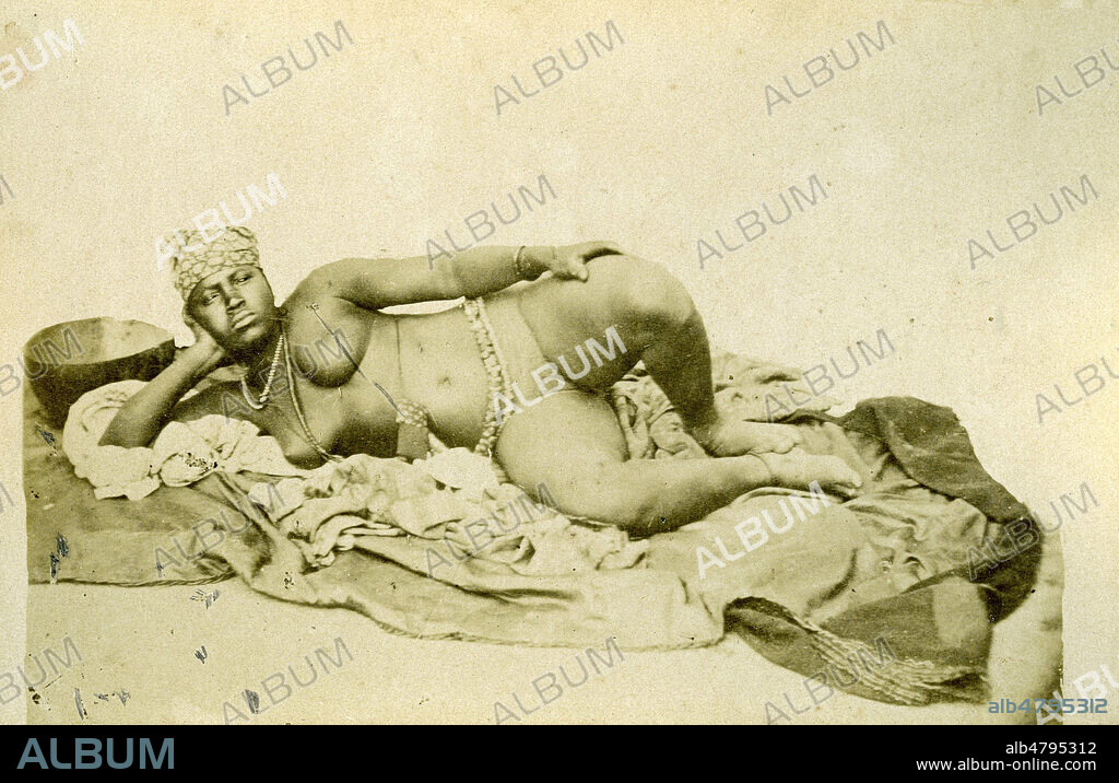 Femme senegalaise nue, allongee. Photographie de 1895 par L. Hostalier. 19eme siecle. Credit : Collection IM/KHARBINE-TAPABOR.