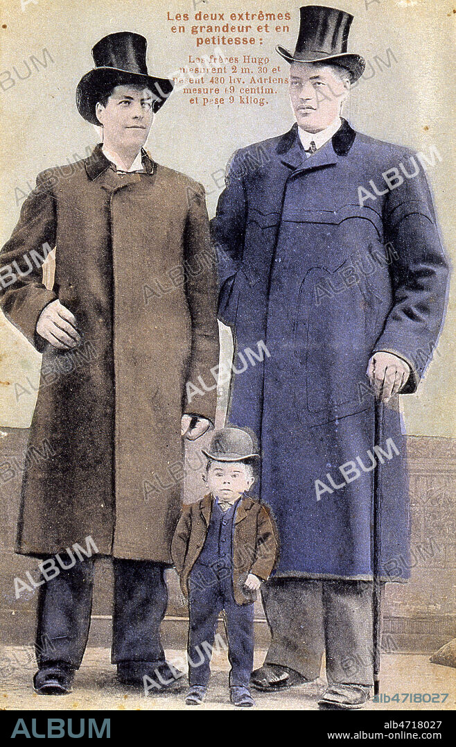 Hommes geants et nain se produisant dans les cirques et les foires au debut du 20eme siecle:'Les deux extremes en grandeur et en petitesse: les freres Hugo mesurent 2m30 et pesent 430 livres, Adriens mesure 69cm et pese 9 kilos'. Carte postale vers 1905. Credit: Cheuva / KHARBINE-TAPABOR.