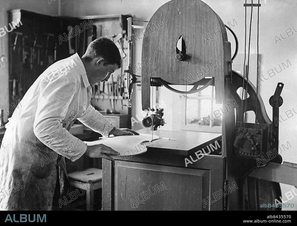TYSKLAND MITTENWALD omkring 1930. Orig. bildtext... MITTENWALD, DIE STADT DES GEIGENBAUS. Aussägen der Form der Geige mit der Bandsäge. Foto: Atlantic Photo-Gesellschaft / AB Text & Bilder / SVT / Kod: 5600 Mapp: Violin tillverkning Tyskland 2094 B Bildserier Fotoreportage Bandsågar sites: MITTENWALD;TYSKLAND PhotoDate:193?-??-??.