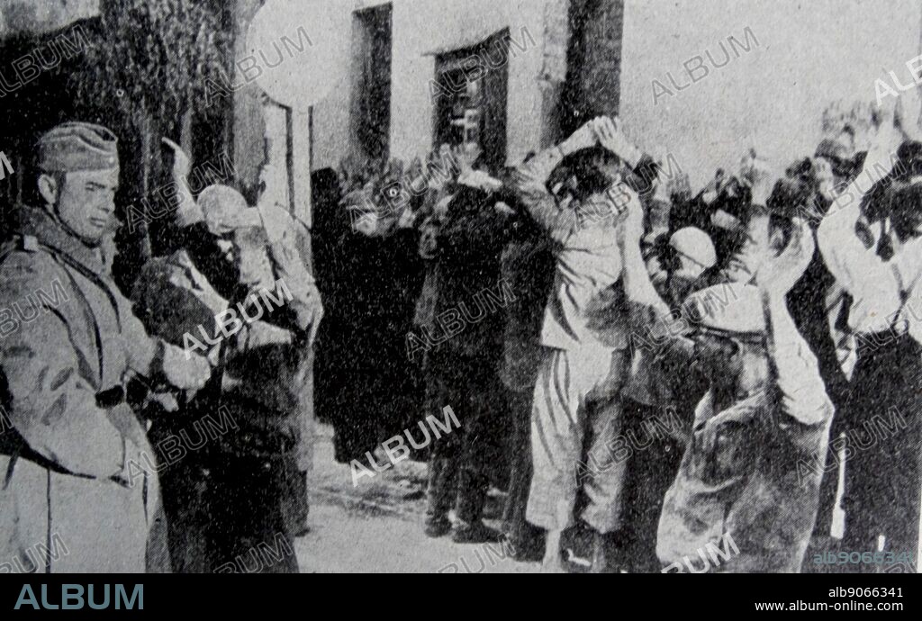 Photograph showing a Gestapo raid on the Warsaw Ghetto. The Gestapo agents of the Secret State Police search the inhabitants. Dated 1941.