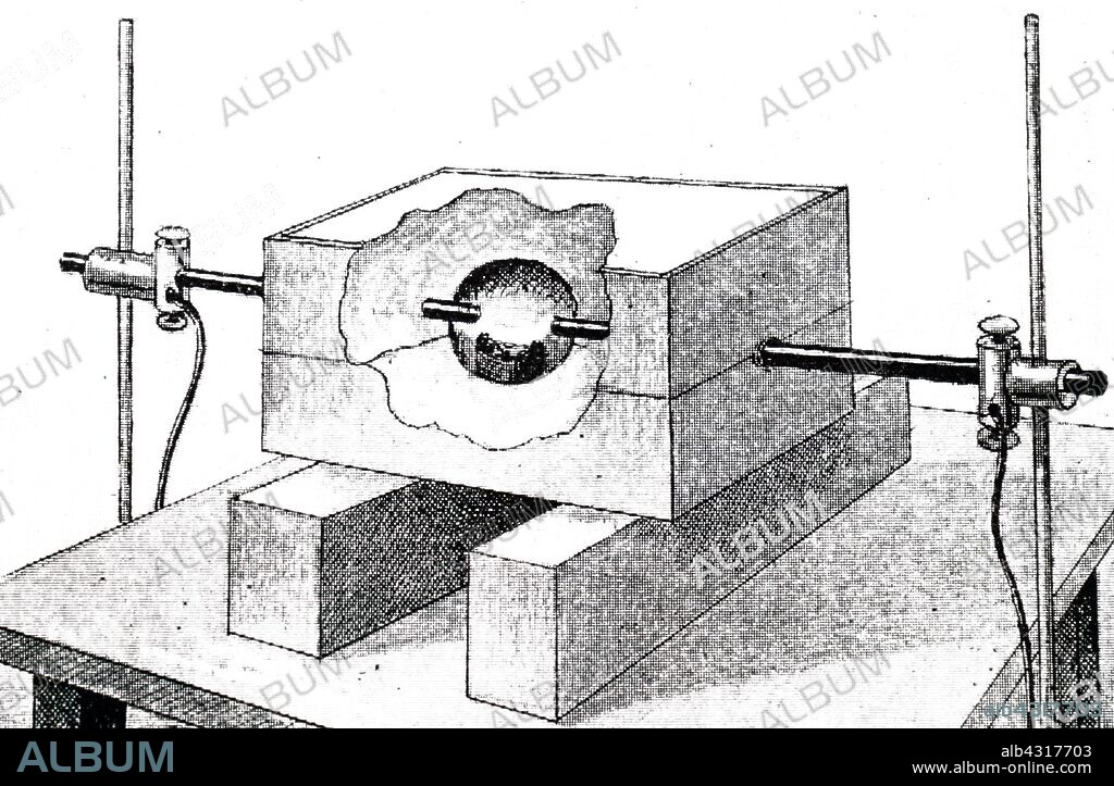 An engraving depicting a sectional view of the electrical furnace used by Henri Moissan to produce artificial diamonds by compressing pure sugar charcoal in a cylinder of soft iron with a soft iron plug: this was put in a crucible containing 200g of molten iron and melted in an electric furnace, the withdrawn and rapidly cooled. Dated 19th century.