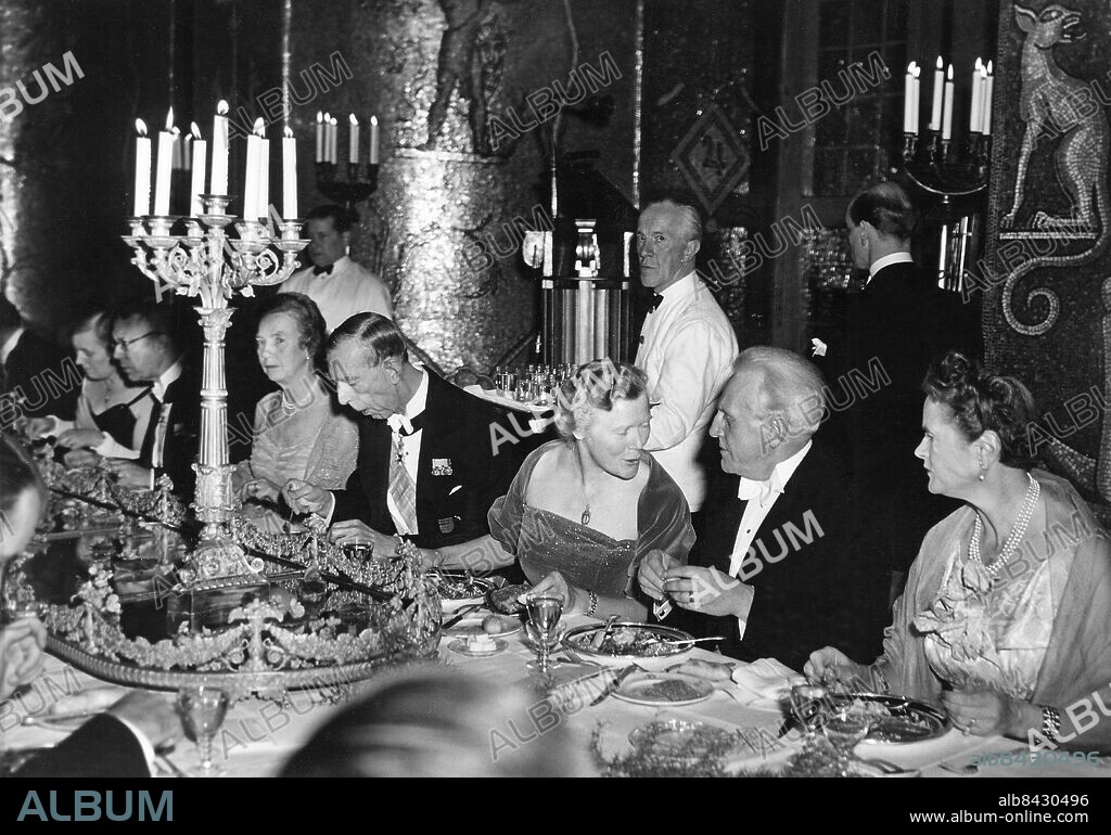 STOCKHOLM 1951-12-10. Orig. bildtext... BORDSSÄLLSKAP VID GALADINEN Fr.h. ses Mme Walloton-de Freudenreich, Pär Lagerkvist, Fru Ambassadör Bergersen, Prins Wilhelm, Fru Elaine Lagerkvist, Konungen, samt Lady Cockcroft. Foto: AB Text & Bilder / SVT / Kod: 5600 Mapp: Nobelpris 1951 1832 B Kandelabrar Kypare persons: GUSTAF VI ADOLF, KUNG AV SVERIGE;WILHELM, PRINS AV SVERIGE;PÄR LAGERKVIST;ELAINE LAGERKVIST sites: STOCKHOLM;SVERIGE.