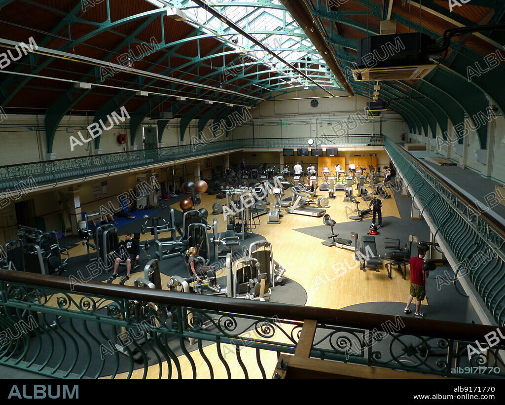 SIMON INGLIS. Wimbledon Leisure Centre, Latimer Road, South Wimbledon, Merton, Greater London Authority, 2011. The former swimming pool hall of Wimbledon Public Baths, converted into a fitness gym as part of Wimbledon Leisure Centre. Wimbledon Baths were opened as a single pool and slipper baths in 1901. A second pool and more baths were built in 1929, with a club room, rifle range, learner pool and cafe being added later. The 1929 pool was converted into a gym, and in the early 21st century the building was known as the Wimbledon Leisure Centre and Spa.
