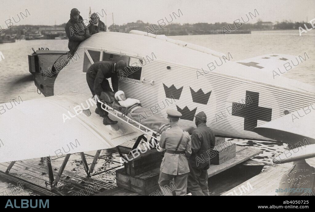 An air ambulance operated by the Swedish Red Cross at sea, Malmö, Sweden, 1923. A bandaged stretcher case being carried aboard.
