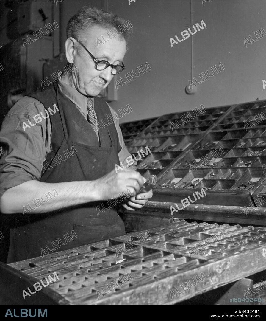 LINDESBERG 1949-06.. Orig. bildtext... REPORTAGE FRÅN BERGSLAGSPOSTEN, LINDESBERG Trots sättmaskinen är inte handsättaren utan arbete. Han står vid en kast i vilken bokstavstyperna ligger ordnade efter ett särskilt system, och därifrån plockar han upp typ efter typ i vinkelhaken och sätter ihop dem till rubrik- eller annonsrader. Anm. Bildserier Fotoreportage Publ i RiR 27/49 CD708 sites: LINDESBERG;SVERIGE.
