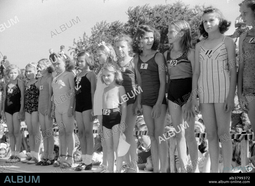Junior entries in beauty contest during July 4th celebration at Salisbury, Maryland. A child beauty pageant is a beauty contest featuring contestants under 18 years of age. Competition categories may include talent, interview, sportswear, casual wear, swim wear, western wear, theme wear, outfit of choice, decade wear, and evening wear. Beauty pageants started in 1921 when the owner of an Atlantic City hotel struck upon the idea to help boost tourism. However, that idea had already circulated through "Most Beautiful Child" contests held in major cities across the country. Photographed by Jack Delano, 1940.