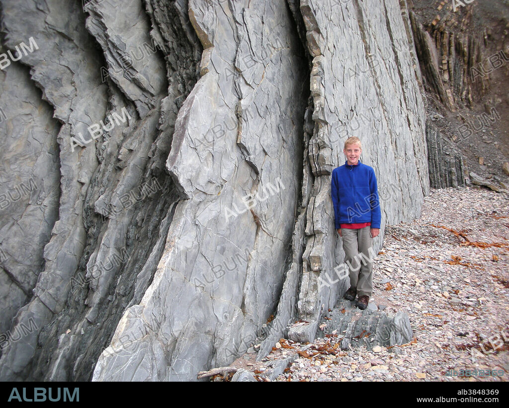 Sedimentary rock strata pushed vertical by geological action. This formation is located in Perce, Quebec, Canada.