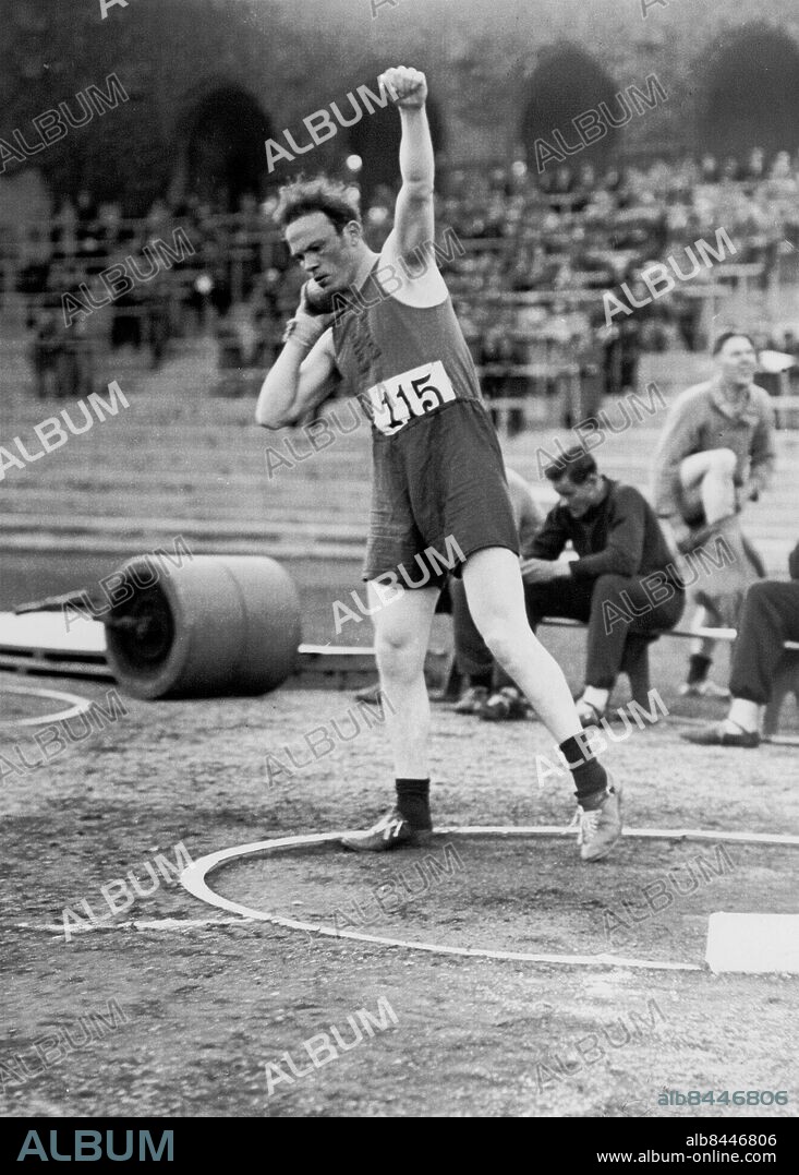 Utan bildtext. Not. Olympiauttagningarna i Stadion 10 juni 1932. Norrby, Hellas, segrar i kulstötning. Norrby, vilken vann kulstötning. Anm. S Norrby, 1906-1955, kulstötare, präst och politiker, vann många SM-guld. Atleter Ansats Rörelse Åskådare Guldmedaljörer Kula CD643 persons: SAMUEL NORRBY sites: STOCKHOLM;SVERIGE.