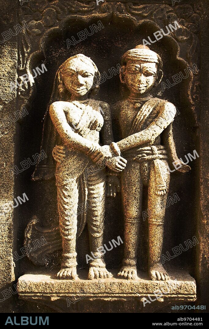 RSC75068 : Indian couple, holding hands, carved on wall of Ahilyabai temple, ornamental carving on stone, old Indian sculpture, Heritage site, in building on Ahilyabai ghat of Narmada river, was named after Ahilayabai, one of the most powerful ruler of Holkar dynasty of Indore, Maheshwar, Madhya Pradesh, India -.