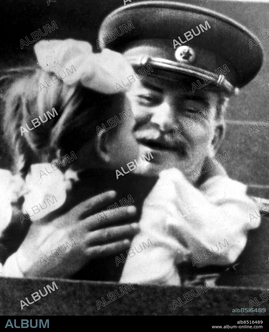 MOSKVA RYSSLAND 5 MAJ 1952 - Josef Stalin is hugged and kissed by Vera Kondakova, a first form pupil of the Moscow scool number 612, after she had presented him with a bouquet of flowers at Lenins Mausoleum during the Moskow May Day celebrations.. Foto: UPI Code: 450. COPYRIGHT PRESSENS BILD.