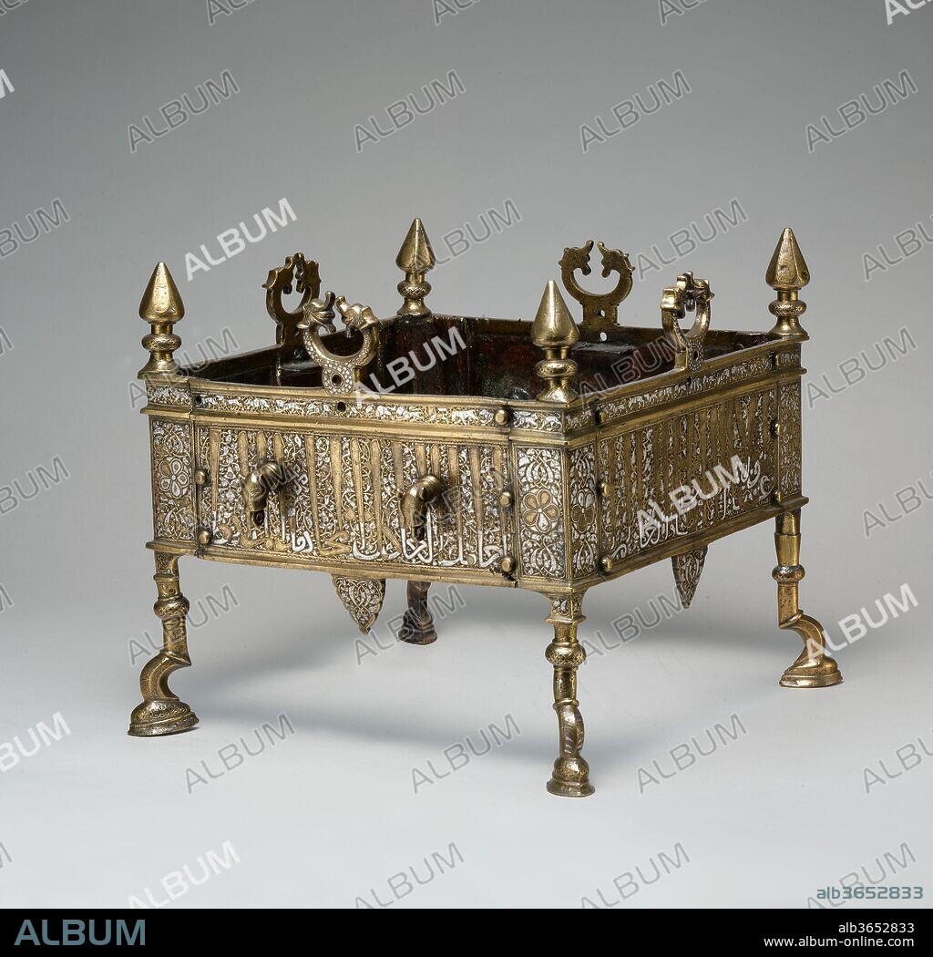 Brazier of Sultan al-Malik al-Muzaffar Shams al-Din Yusuf ibn 'Umar. Dimensions: H. 13 7/8 in. (35.2 cm)
W. 15 1/2 in. (39.4 cm)
Max Depth. 16 3/8 in. (41.6 cm). Date: second half 13th century.
Braziers served as portable grills and heaters. The lionheaded knobs with rings provided receptacles for handles to transport the heated unit, while the confronted dragon heads on each side functioned as spit brackets. The names and honorifics mentioned in the monumental inscription identify the patron, the second ruler of the Rasulid dynasty (r. 1250-95). His dynastic emblem, a five-petalled rosette upon a circular shield, features prominently on both sides of each corner bracket.