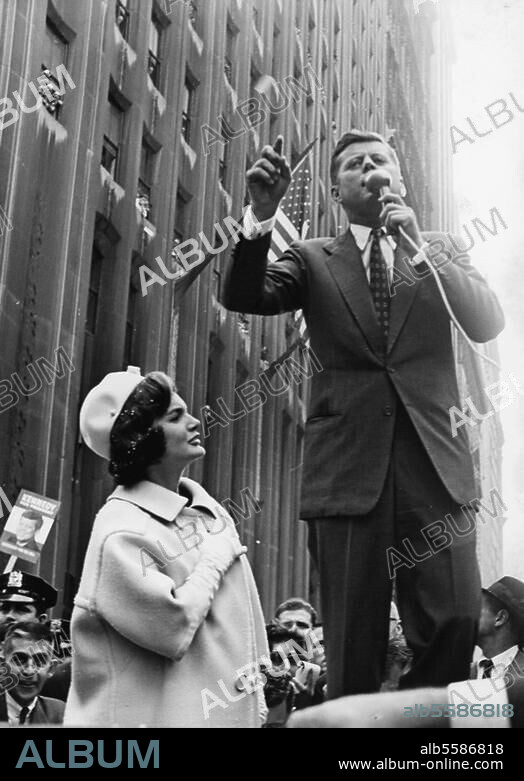 Kennedy, John Fitzgerald amerik. Politiker, 1917-1963. John F. Kennedy als Präsidentschaftskandidat der Demokraten auf Wahlreise in New York: Kennedy spricht in seinem Wagen stehend zu den Straßenpassanten, neben ihm seine Frau Jacqueline. Foto, 24.10.1960.