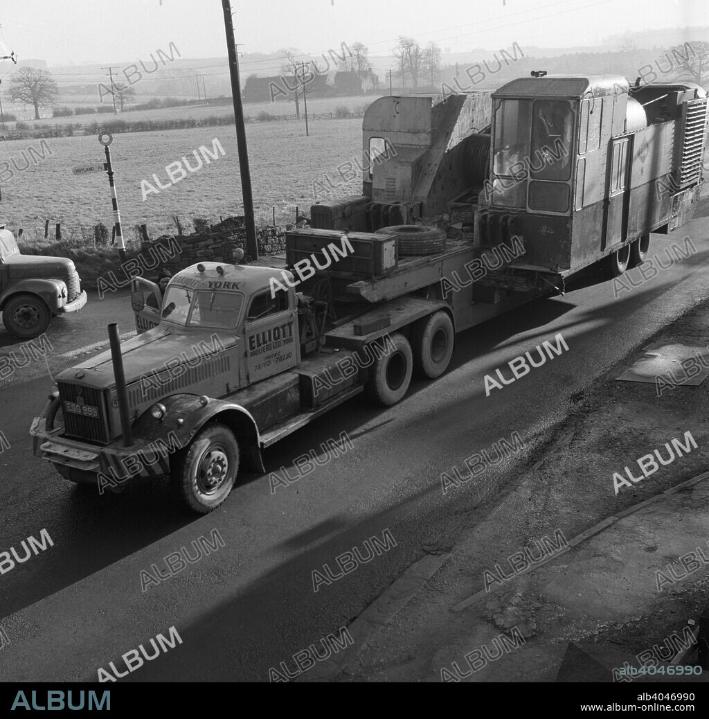 Early 1940s Diamond T truck pulling a large load, South Yorkshire, 1962. The truck, bearing the unusual registration number of EGG 999 pulls the body of a 2400 Lima drag line unit on a low loader near the village of Hoyland, near Barnsley. The American tractor unit was probably ex US military and looks like a 1943 model. It was operated by Elliott Hauliers Ltd of York.