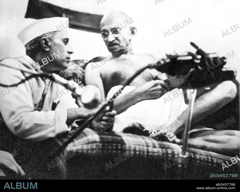 Cushion Conference -- Pandit Jawaharlal Nehru and Mohan Das K. Gandhi, the latter comfortably reclining on cushions, confer during the All-India Congress session in Bombay a few hours before their arrest August 8. Gandhi today became 73 years old. And 2,000 of his followers marked his Birthday by throwing stones at police. October 02, 1942. (Photo by AP Wirephoto).