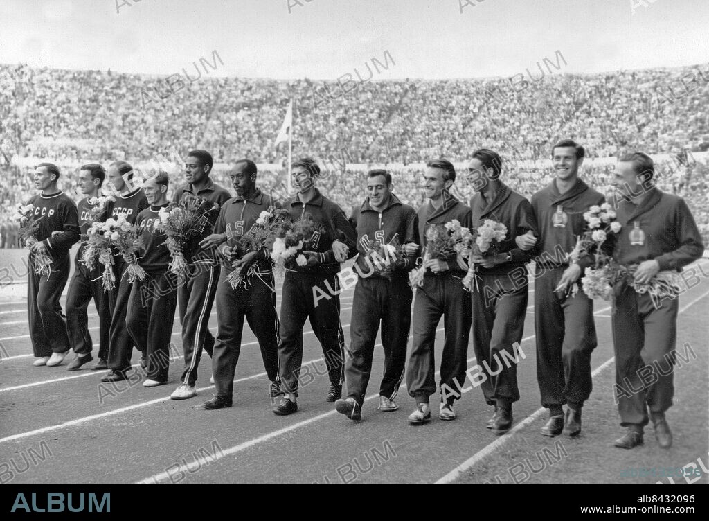FINLAND HELSINGFORS 1952-07-27.. De tre medaljlagen i stafetten på 4 x 100 meter för herrar med sina blommor på Olympiastadion i Helsingfors vid de olympiska sommarspelen 1952. USA vann på tiden 40,1 sek, Sovjetunionen kom tvåa på 40,3 sek och Ungern trea på 40,5 sek. Det sovjetiska laget (tv) bestod av Boris Tokarev,. Levan Kaljajev, Levan Sanadze och Vladimir Sucharev, USA:s lag (i mitten) av Andy Stanfield, Harrison Dillard, Dean Smith och Lindy Remigino, och Ungerns lag (th) av László Zarándi, Géza Varasdi, György Csányi och Béla Goldoványi.. Foto: Olympic World Photo Pool / AB Text & Bilder / SVT / Kod: 5600. Engelsk originalbildtext.. Mapp: Stafetter I:286K . Segrare Vinnare På rad.