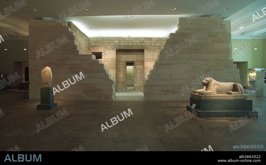 Mastaba Tomb of Perneb. Dimensions: H. 482.2 cm (15 ft. 9 13/16 in.). Dynasty: Dynasty 5. Reign: reigns of Isesi to Unis. Date: ca. 2381-2323 B.C..
The Location of Perneb's Tomb 
For millennia, the vast cemetery of Saqqara (about twenty-five miles south of Cairo) was the burial ground for Memphis, ancient Egypt's capital. In an especially crowded section, just north of the enclosure around King Djoser's Step Pyramid at Saqqara (built during Dynasty 3, ca. 2650 B.C.), a number of courtiers and royal family members of Dynasty 5 (ca. 2465-2323 B.C.) were buried. Among them were Perneb and the vizier Shepsesre, who may have been Perneb's father. 
Perneb's Tomb: A Mastaba
In many societies graves are covered with mounds of earth and stone. By the beginning of Dynasty 1 (ca. 3100 B.C.) the ancient Egyptians had transformed that simple scheme into a formalized building type that Egyptologists call a mastaba (from the Arabic word for "bench"). The typical mastaba of Perneb's time was built of stone or brick. Its shape was rectangular, and its height roughly that of a one-story modern house. The roof was flat; the sides were inclined and most often unadorned except for some architectural articulation around the doorway and an occasional inscription along the top and corners. To serve the needs of larger communities, great numbers of mastabas were arranged in rows, forming veritable "cities of the dead."
Perneb's Tomb Built Against the Tomb of Shepsesre
The builders of Perneb's mastaba took advantage of the earlier large tomb of the vizier Shepsesre. By leaning the two projecting wings of Perneb's tomb superstructure against the strong west wall of Shepsesre's tomb, they gained not only structural stability but also space for an interior courtyard. In order to present the architecture of Perneb's tomb in a manner as close as possible to that of the original, the present installation includes a partial reconstruction of the west wall of the Shepsesre tomb. The limestone blocks used in this reconstruction come from Helwan, south of Cairo, a quarry near the ancient source of Perneb's building material. The stepped face of the reconstructed wall inside the courtyard reproduces the appearance of the original. Its center is shown, however, in ruined condition, so that visitors entering from the Museum's Great Hall can glimpse the courtyard and interior façade of Perneb's monument.
The Interior Rooms of Perneb's Mastaba and the Burial
Up to and through Dynasty 4, most of the interior space of a mastaba was packed with rubble, and only a few rooms, if any, were built within the compact mass. The number of rooms increased during Dynasties 5 and 6, especially for persons of high status, but the basic concept of a compact rectangle of stone or brick was never quite abandoned. Within Perneb's mastaba four rooms were prepared: an entrance passage in the center (originally the west wall), a vestibule, an inner passage connecting the vestibule with the offering chamber, and the main offering chamber. In addition, there are an entrance chamber in the right (originally north) wing and an offering chamber in the left (originally south) wing. The latter is connected to the statue chamber (or serdab) by a small slot in the wall.
Also in each mastaba at least one shaft was sunk vertically through the rubble fill to reach the burial chamber in the bedrock below. After deposition of the mummy and its accompanying burial equipment, the shaft was filled in. (Perneb's shaft and burial are not preserved here.) But the rooms in the superstructure remained accessible to relatives and friends of the deceased who visited the tomb to make offerings and perform rituals.
The Tomb as a House
With the addition of the reconstructed wall, Museum visitors can experience the tomb much as ancient Egyptians did. As originally, one passes through a small entrance chamber into an interior courtyard, which was open to the sky but closed on all four sides.
Ancient visitors would have felt very much at home in this intimate space; many of its architectural elements were familiar from the homes they lived in. Entry into their houses was through just such a small doorway, and in the privacy of the courtyard women would attend to the laundry or cook a meal. The recessed central doorway overlooking the courtyard indicated the entry into the interior of the house, where the master awaited his guests.
The Tomb as a Sacred Place
A tomb, however, is not just a house for the dead. It is a sacred place dedicated to the belief in life after death. This aspect was emphasized in Perneb's tomb by two small obelisks (now missing) at the western corners of the courtyard. They evoked the presence of the sun god Re who, especially in Perneb's time, was venerated as the ultimate source of life in grandiose solar temples built around huge obelisks. Most importantly, the interior rooms of the mastaba were places for the performance of life-renewing rituals. Eternalized in the wall decorations, these rituals and the offerings that accompanied them provided the deceased with everlasting sustenance. The statues in the serdab represented the tomb owner as a living person who could receive the potent life forces activated through the chants and incense burning that took place in the south offering chamber.