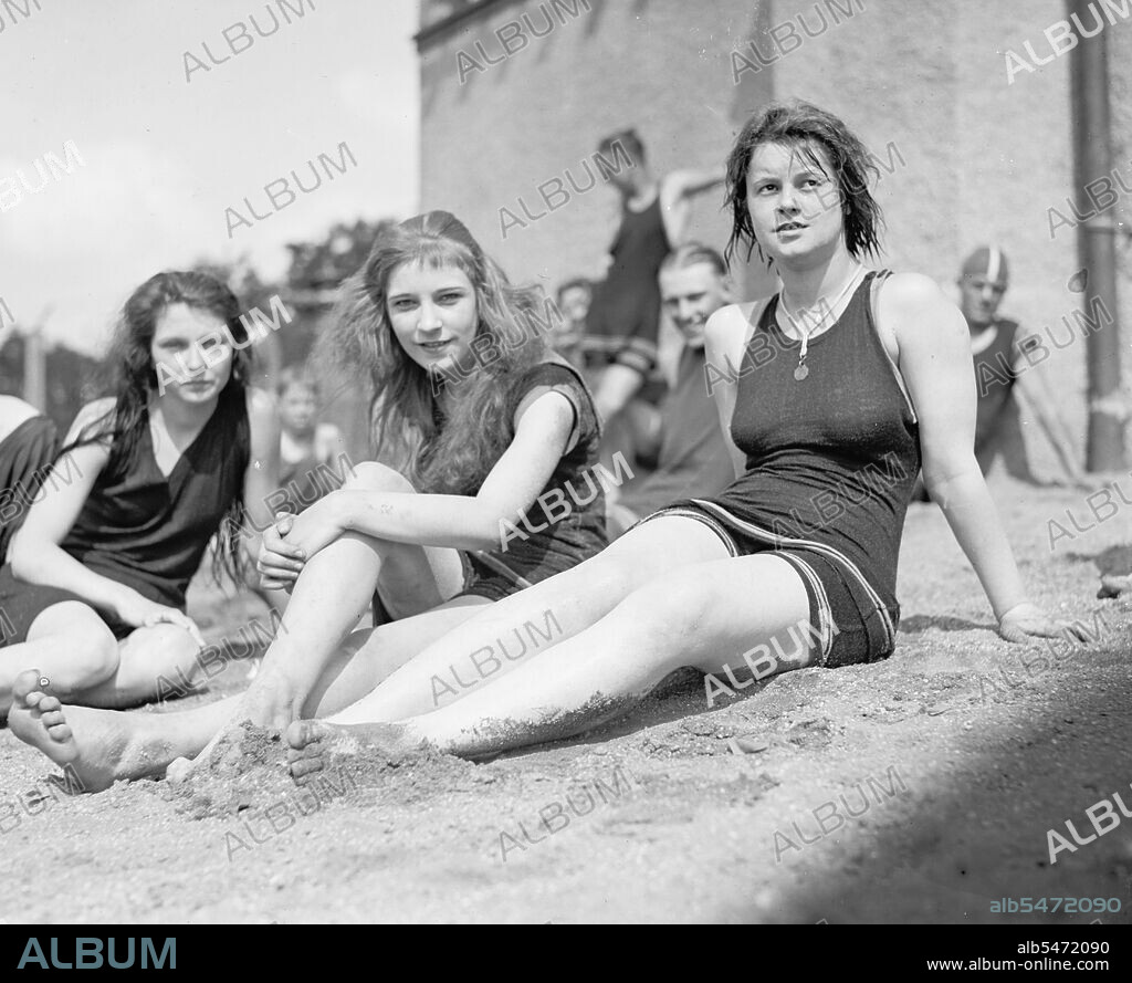 Young women or teen girls sitting on a beach ca. between 1909 and 1932.