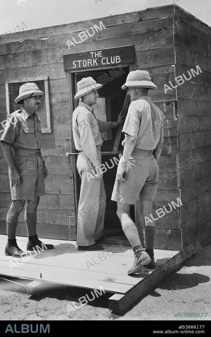Officers entering their mess, a version of the famous Stork Club in New York, which is constructed of used airplane crates, India. circa 1942.