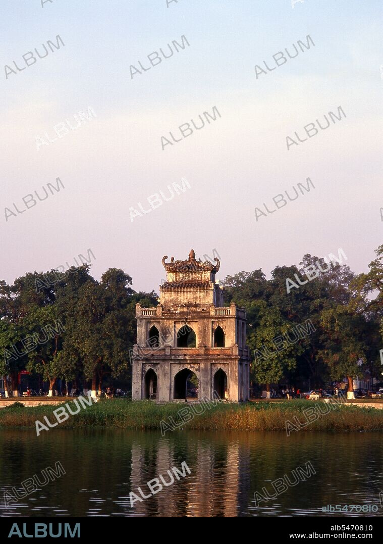 Ho Hoan Kiem means ‘Lake of the Restored Sword’, a body of water that lies at the heart of Hanoi. Until the 15th century it was called Luc Thuy or ‘Green Water’. Legend has it that during the Ming occupation (1407-28), General Le Loi was presented with a magical sword by a divine turtle that lived in the waters. With the help of this sword, Le Loi expelled the Chinese from northern Vietnam and established himself as Emperor Le Thai To. Later, when the emperor was sailing on the lake, the turtle rose to the surface and reclaimed the sword. Ever since it has been known as Ho Hoan Kiem. Thap Rua (Turtle Tower), a small pagoda, was built in the mid-19th century on an islet in the centre of the lake to commemorate this supernatural event, and the structure has since become an icon of Hanoi. According to the prestigious journal Vietnamese Studies, Thap Rua is ‘like the Eiffel Tower to Paris, or the Statue of Liberty to New York’. Every day Radio Hanoi starts its programmes with the song: ‘Wherever we find ourselves at the four points of the compass, our hearts turn to Hanoi; the clear waters of the Lake of the Restored Sword, which mirror the reflection of Turtle Tower’. There is no access to the tiny island.