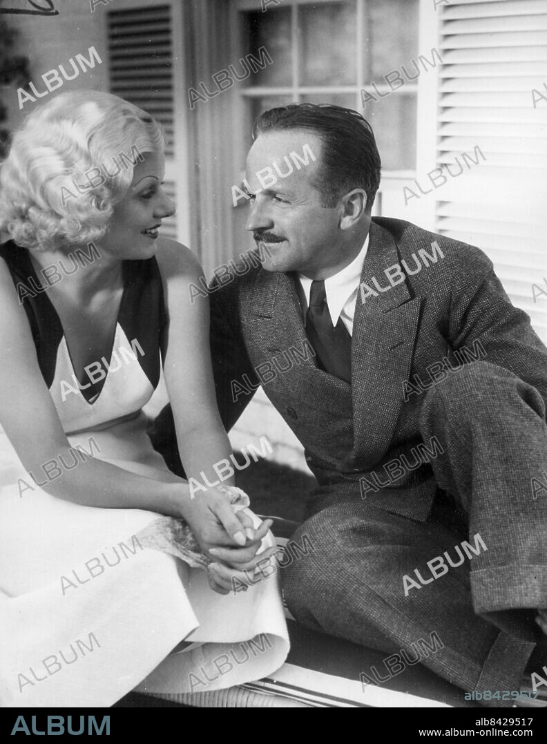 Orig. bildtext... FILDOM'S NEWEST NEWLYWEDS. A few hours after their midnight air elopement to Yuma, Ariz., Jean Harlow, original platinum blonde of the screen is seen here with her husband, Harold G. Rosson, 38, Hollywood ace photographer, in the garden of Miss Harlow's Hollywood home. Rosson photographed the last four pictures in which Miss Harlow appeared. This is her third marriage. 9/19/33 Anm. J Harlow, eg. Harlean Carpenter, 1911-1937, amerikansk skådespelerska. Gift med H Rosson 1933-1934. H Rosson, 1895-1988, amerikansk filmfotograf. Profiler Mustascher Knäppta händer CD601 persons: JEAN HARLOW;HAROLD ROSSON sites: USA;HOLLYWOOD.