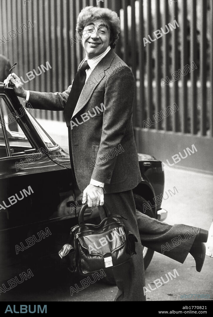 Portrait of Gino Bramieri. The Italian comedian and actor Gino Bramieri leans against the door of a car. Rome, 1973.