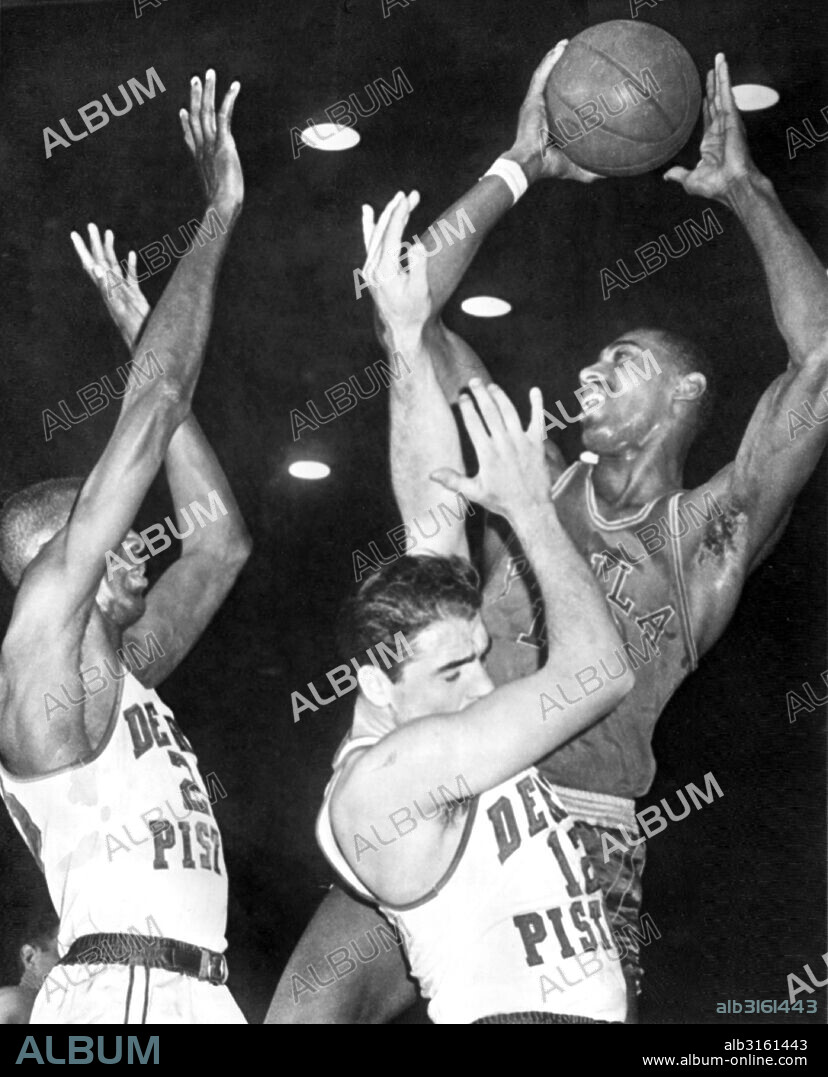 Detroit, MIchigan: February 8, 1961 Detroit Piston players Walter Dukes, (left) and George Lee can't get high enough to block the Philadelphia Warriors' Wilt Chamberlain's shot.