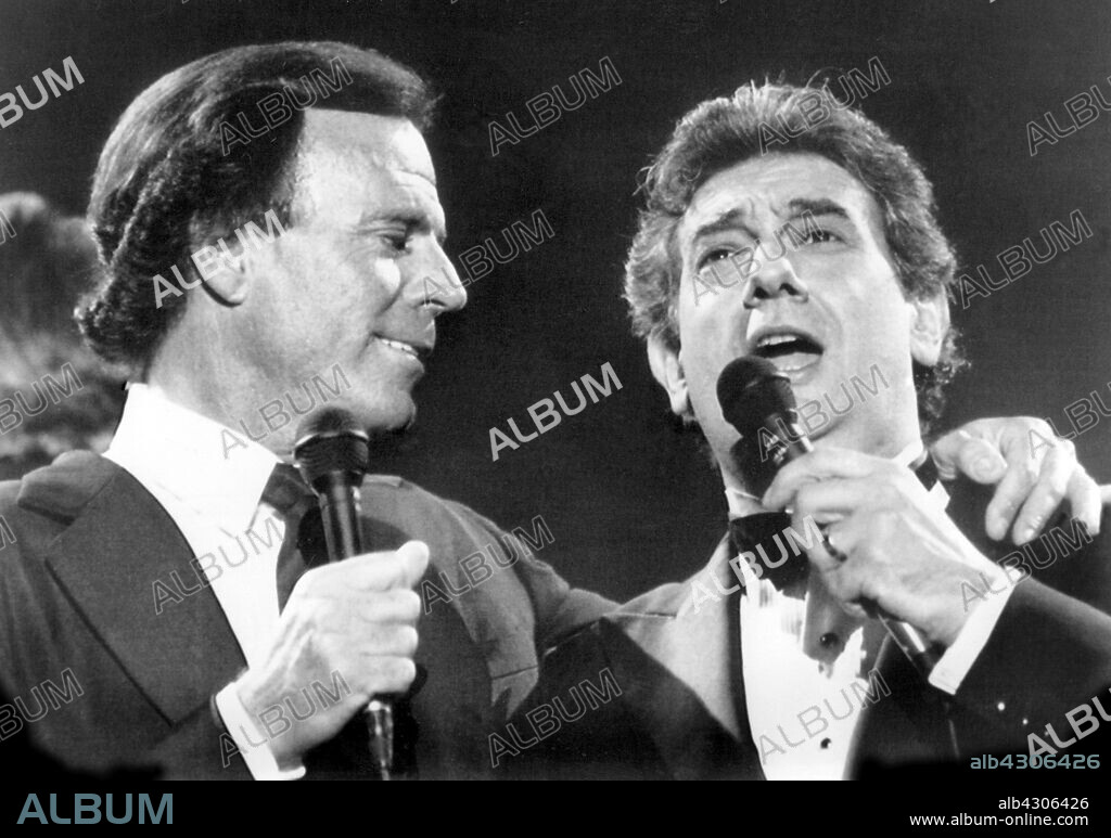 ESPAÑA MÚSICA DÍA DE LA HISPANIDAD: SEVILLA, 12/10/1989.- El cantante Julio Iglesias (i) y el tenor Plácido Domingo interpretan a dúo el tema "Soñadores de España", que han estrenado hoy en el concierto celebrado en el estadio Sánchez Pizjuan, de Sevilla, con motivo del Día de la Hispanidad. EFE/Eduardo Abad.. SPAIN MUSIC HISPANIC WORLD DAY: SEVILLE, 12/10/1989.- Spanish tenor Placido Domingo (R) and singer Julio Iglesias (L) perform a duo during their concert at the Sanchez Pizjuan stadium in Seville, on the occasion of the Hispanic World Day. EFE/Eduardo Abad/fs.