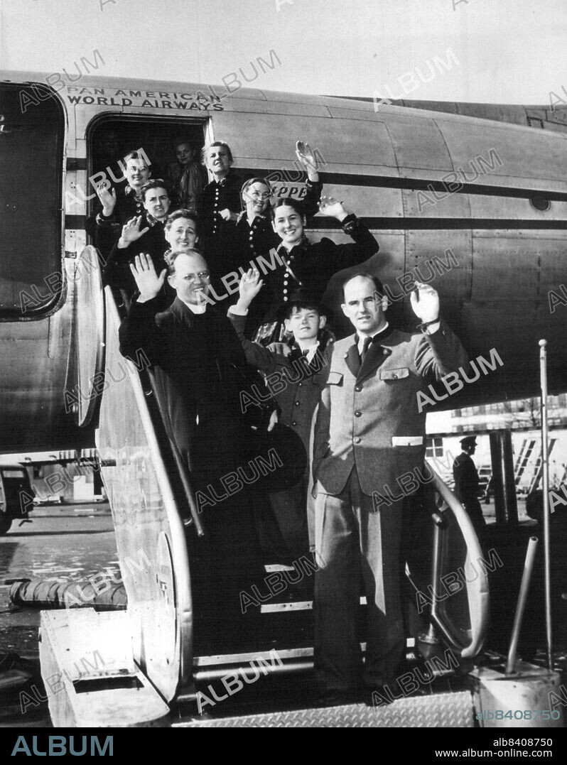 Nine members of the Trapp family, famed Austrian choral group are shown as they prepared to board a plane at New York for a concert tour of Latin American countries. The group is composed of Mrs. Maria Trapp, widow of an Austrian naval hero of World War I, Baron Gerose von Trapp; her daughters, Agatha, Hedwig, Martina, Maria and Eleanore; her sons, Werner and Johannes, and the family's priest-conductor, the Rev. Franz Wasner. February 6, 1955. (Photo by Associated Press Photo).