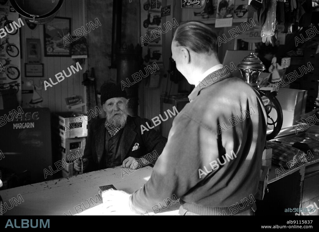 Rukkedalen in Hallingdal 1963 From the old land trader in Rukkedalen in Hallingdal. Krambu. Country trade. The owner Arne S. Eidal has good contact with his customers. The customer in front of the counter is the village's oldest inhabitant, Ola Brusletten. Old man with a beard. Photo: Sverre A Børretzen / Current / NTB   Supplementary information: Eidal Landhandel in Rukkedalen has been elected to the Millennium for Nes in Buskerud in the year 2005.